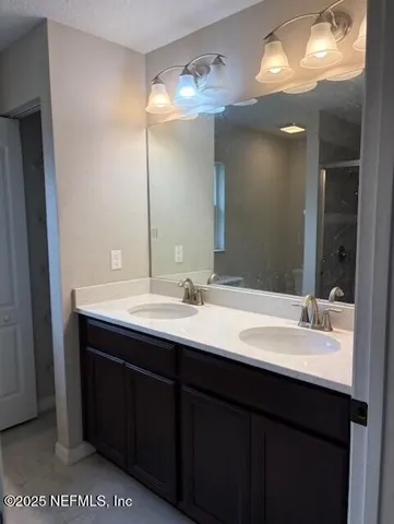 a bathroom with a double vanity sink and a mirror