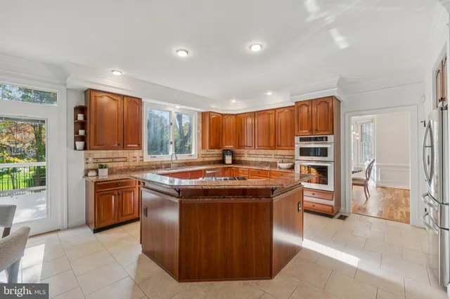 a kitchen with stainless steel appliances granite countertop a stove a sink dishwasher and a refrigerator
