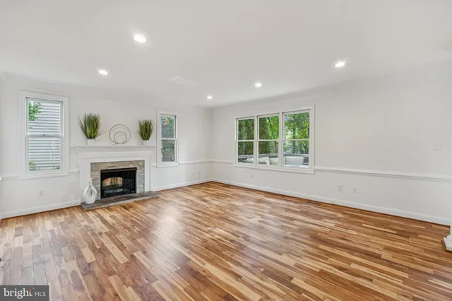 a view of empty room with wooden floor and fireplace