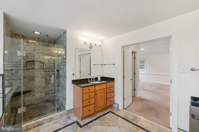 a bathroom with a granite countertop sink mirror and shower