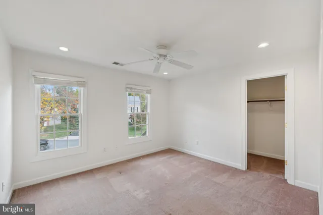 an empty room with windows and closet