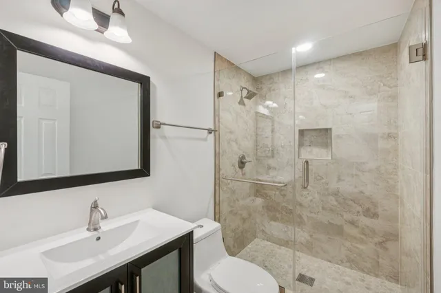 a bathroom with a sink toilet a mirror and shower