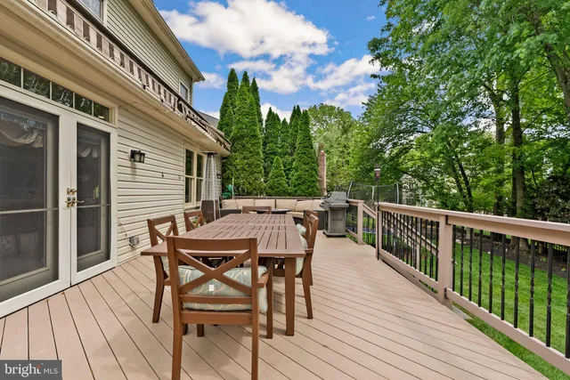 a balcony with wooden floor table and chairs