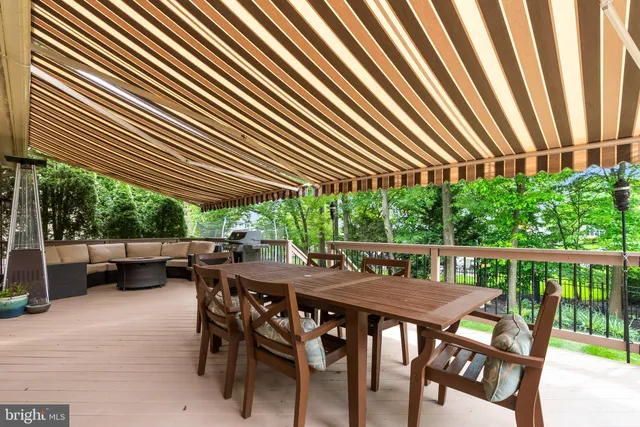 a view of a patio with table and chairs with wooden floor and fence
