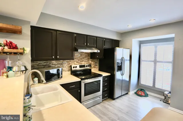 a kitchen with stainless steel appliances granite countertop a refrigerator sink and stove