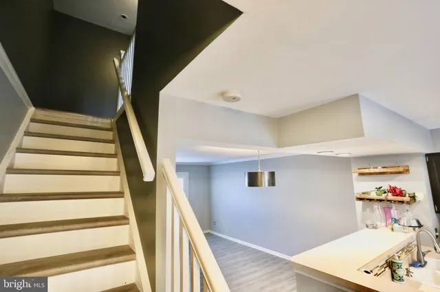 a view of a hallway with wooden floor and furniture