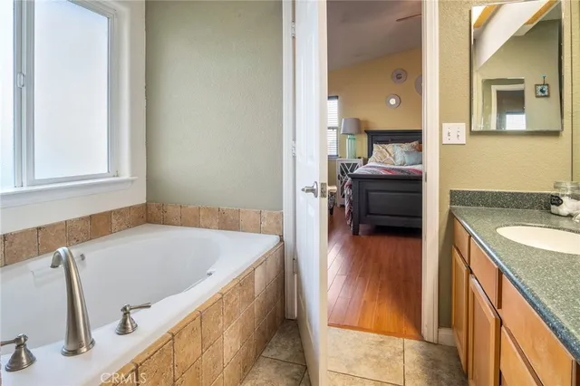 a bathroom with a tub sink and mirror