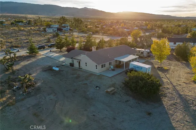 an aerial view of a house with a mountain