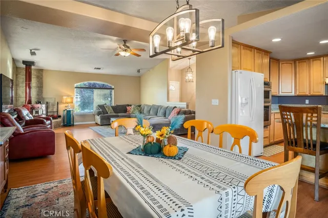 a living room with dining table and a chandelier