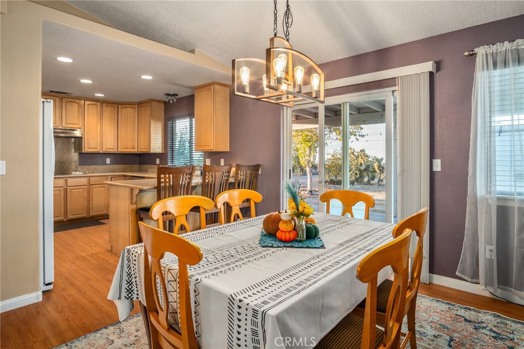 388 Calaveras Road Pinon Hills, CA 92372 - Photo 9 of 44 a kitchen with a refrigerator a sink dishwasher a dining table and chairs with wooden floor