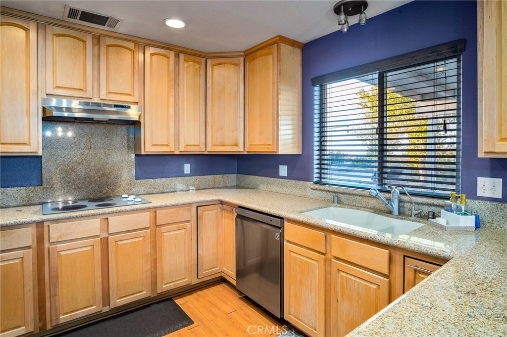 388 Calaveras Road Pinon Hills, CA 92372 - Photo 10 of 44 a kitchen with granite countertop wooden cabinets a sink and a window
