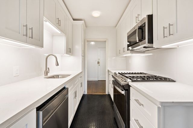 a kitchen with stainless steel appliances granite countertop a sink stove and refrigerator