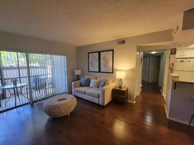 a living room with furniture and a wooden floor