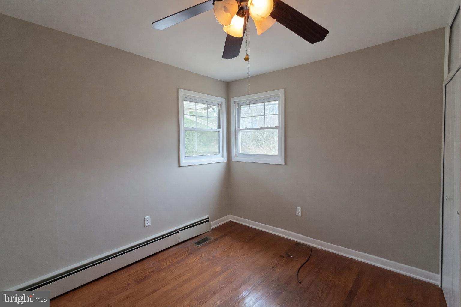6125 Fishers Station Road Lothian, MD 20711 - Photo 14 of 23 an empty room with wooden floor chandelier fan and windows