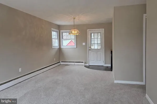 an empty room with windows and chandelier