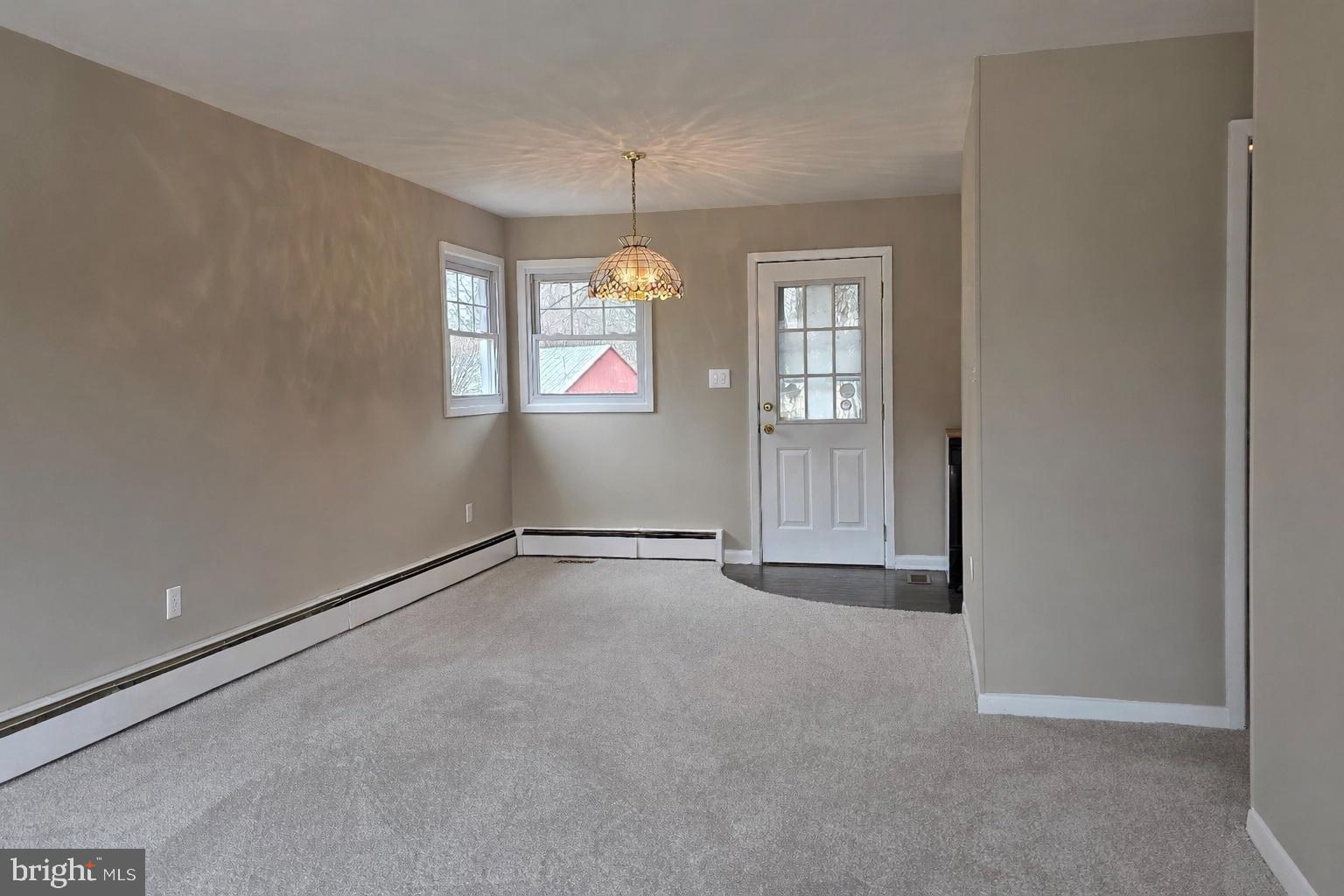 6125 Fishers Station Road Lothian, MD 20711 - Photo 4 of 23 an empty room with windows and chandelier