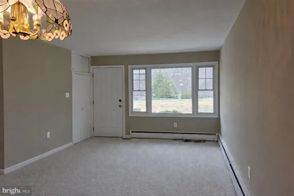 an empty room with windows and chandelier