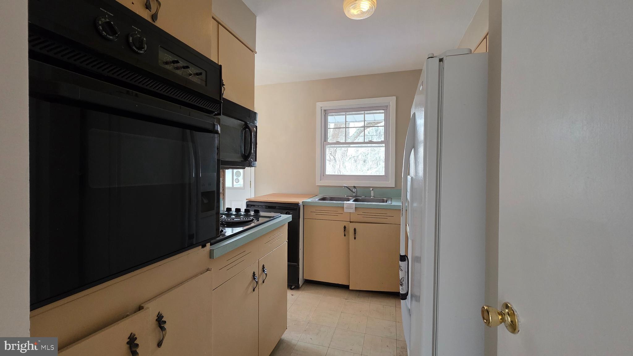 6125 Fishers Station Road Lothian, MD 20711 - Photo 8 of 23 a kitchen with a refrigerator and a sink