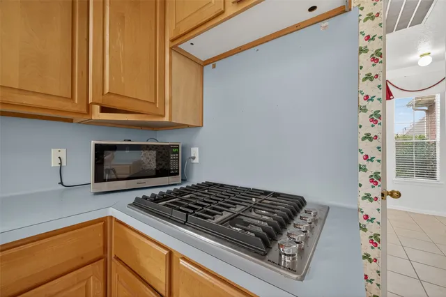 a kitchen with wooden cabinets and a stove top oven
