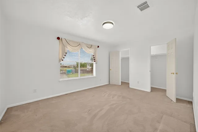 an empty room with windows and closet