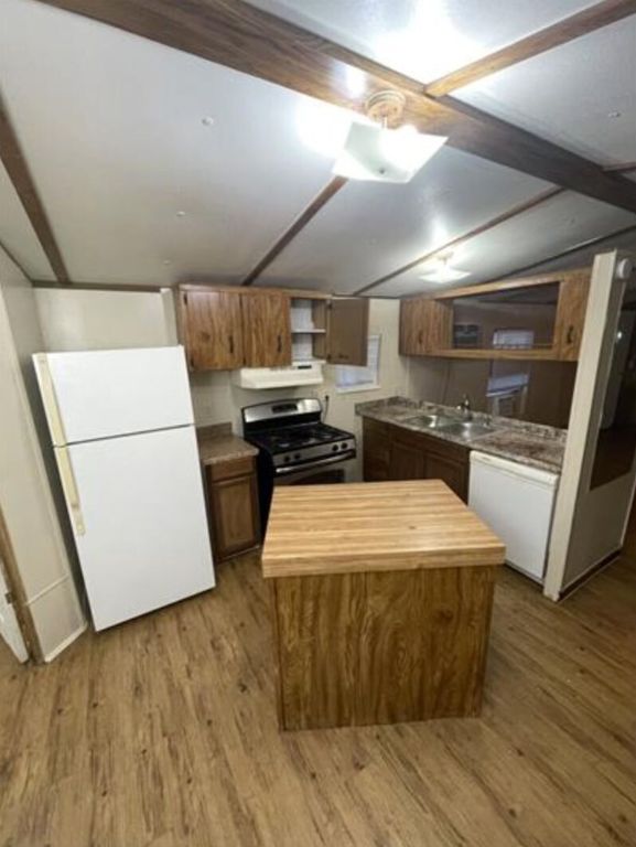 a kitchen with stainless steel appliances a refrigerator sink and wooden cabinets