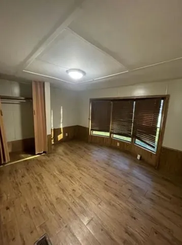 a view of an empty room with wooden floor