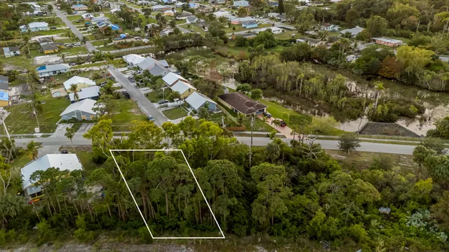 an aerial view of residential houses with outdoor space and trees