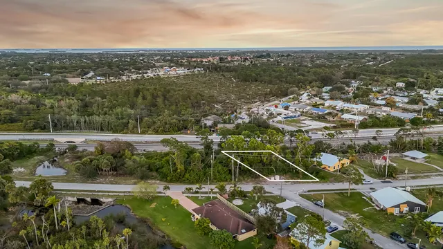 an aerial view of residential houses with outdoor space and trees