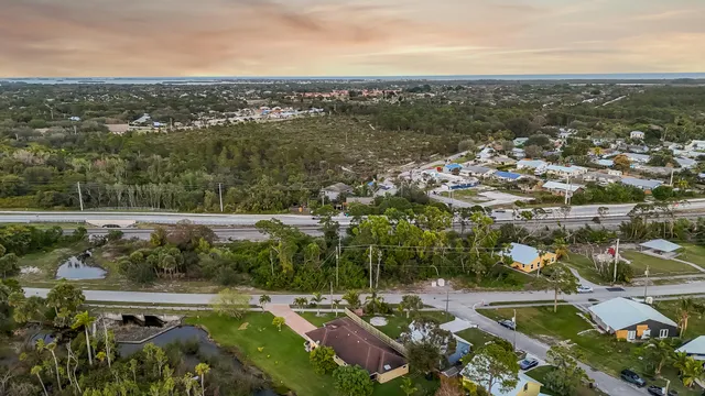 an aerial view of residential houses with outdoor space and trees