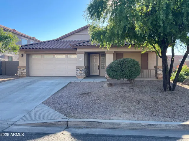 a view of a house with a yard and large tree