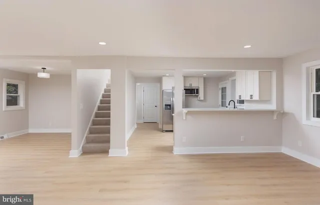 a view of a kitchen with wooden floor and electronic appliances