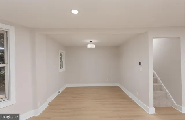 a view of a room with wooden floor and white walls