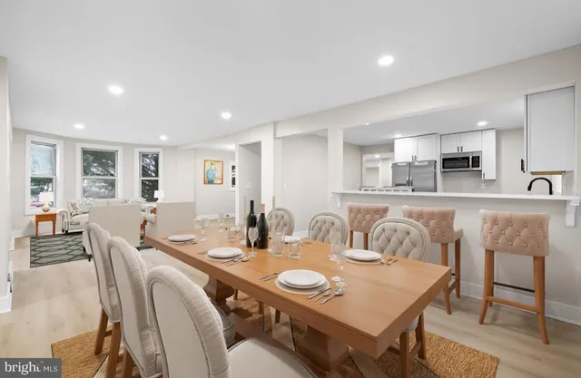 a view of an empty room with wooden floor and windows