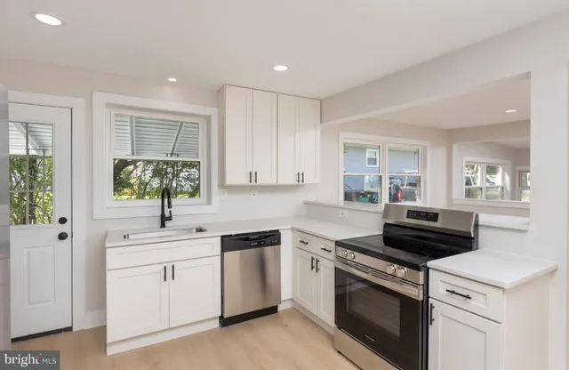 a kitchen with a stove sink and cabinets