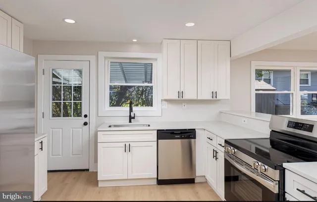 a kitchen with white cabinets and appliances