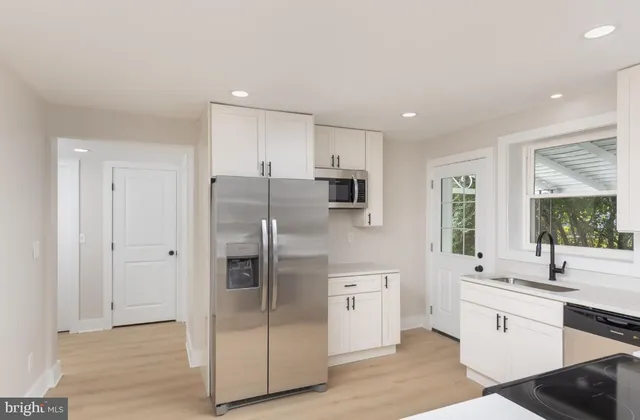 a kitchen with stainless steel appliances a refrigerator sink and cabinets