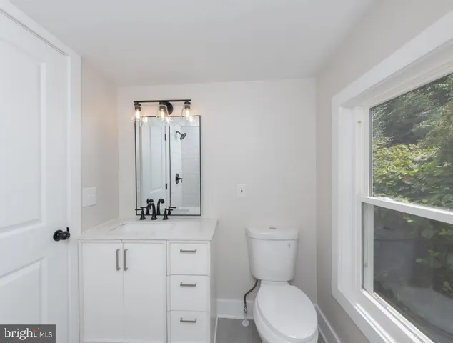 a bathroom with a toilet a sink and mirror
