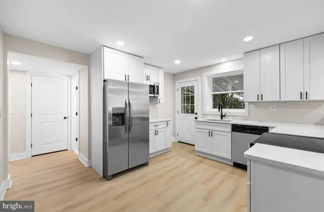 a kitchen with granite countertop a stove top oven sink and cabinets