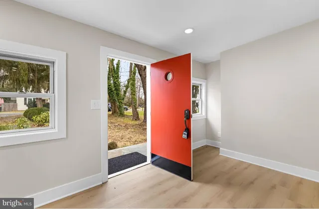 a view of a kitchen with refrigerator and white cabinets