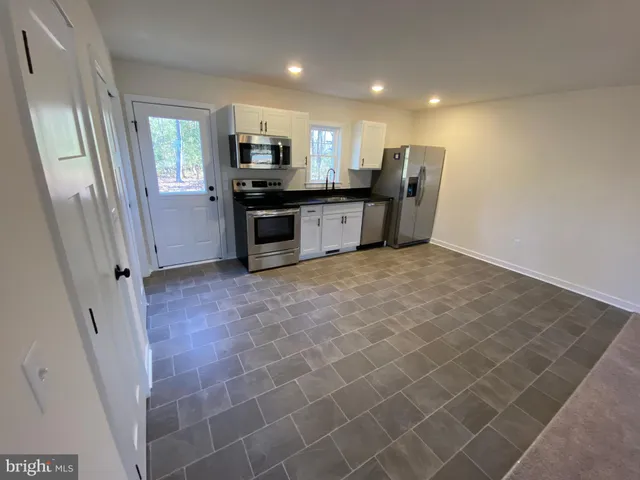 a large kitchen with cabinets and stainless steel appliances