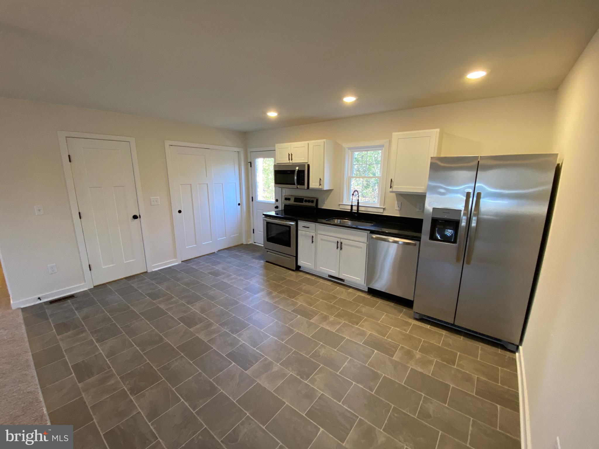 170 Forest Grove Road Colonial Beach, VA 22443 - Photo 13 of 34 a kitchen with granite countertop a refrigerator and a stove top oven