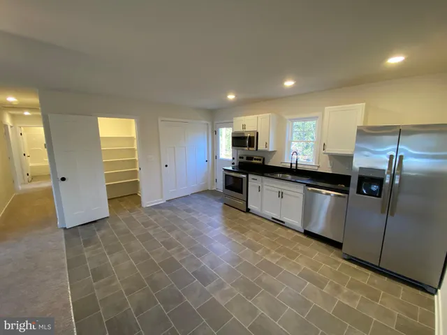 a kitchen with stainless steel appliances granite countertop a refrigerator and a sink