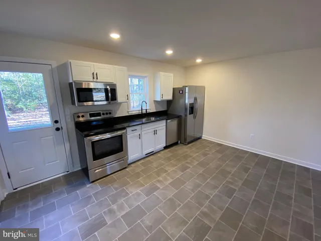 a kitchen with stainless steel appliances a sink stove and microwave