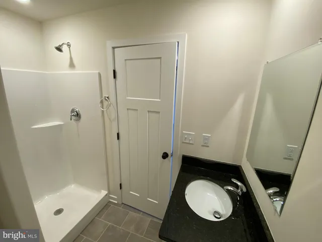 a bathroom with a shower and a glass door
