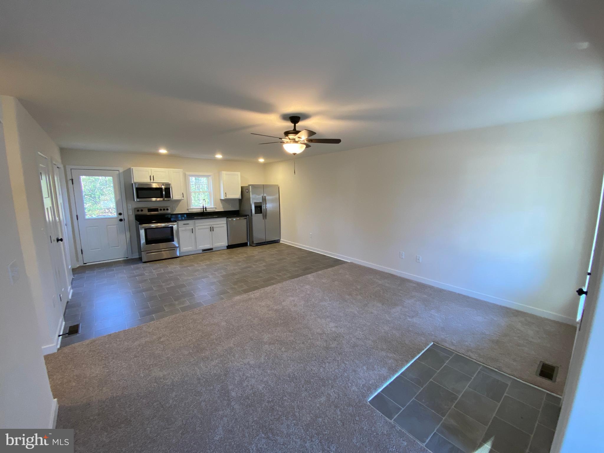 170 Forest Grove Road Colonial Beach, VA 22443 - Photo 10 of 34 a view of a livingroom with a kitchen and a stove top oven