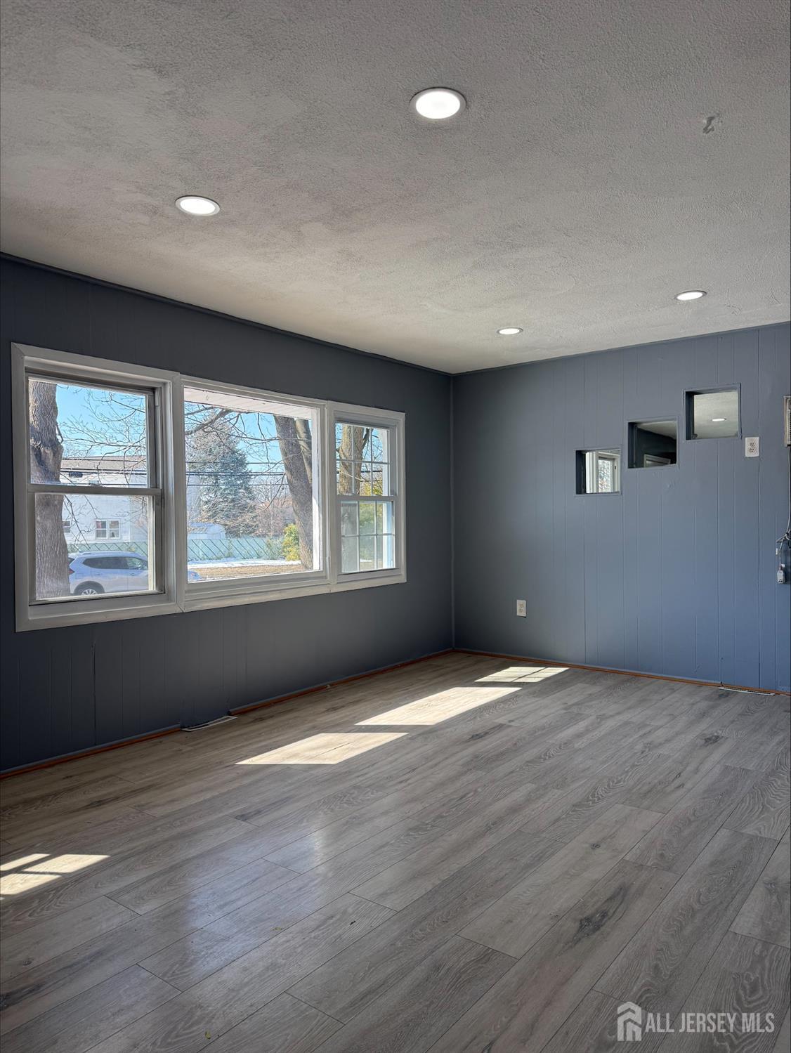 1211 Stelton Road Piscataway, NJ 08854 - Photo 3 of 16 an empty room with wooden floor and windows