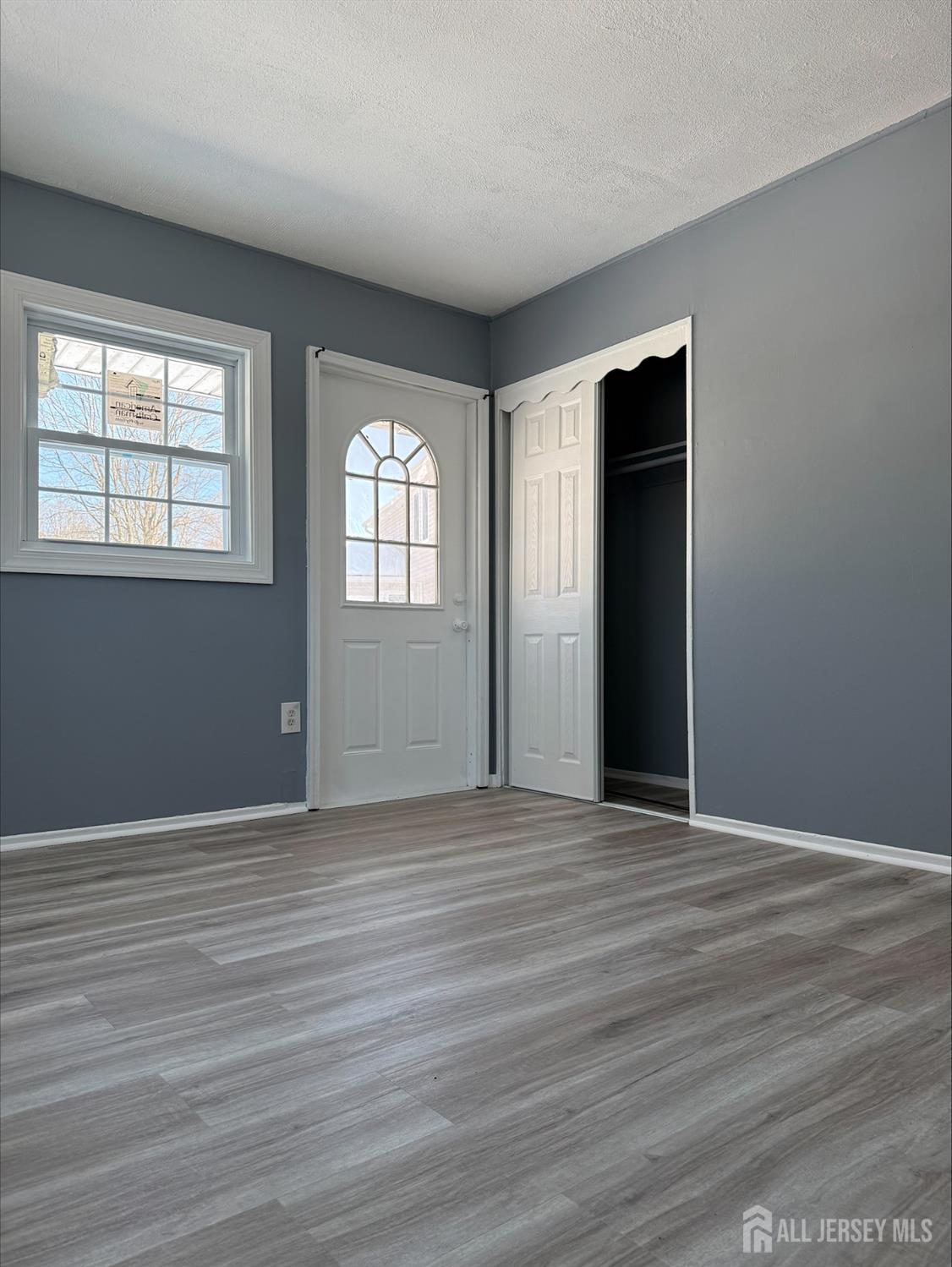 1211 Stelton Road Piscataway, NJ 08854 - Photo 4 of 16 an empty room with wooden floor and windows