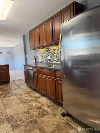 a kitchen with stainless steel appliances granite countertop a stove a sink and a refrigerator