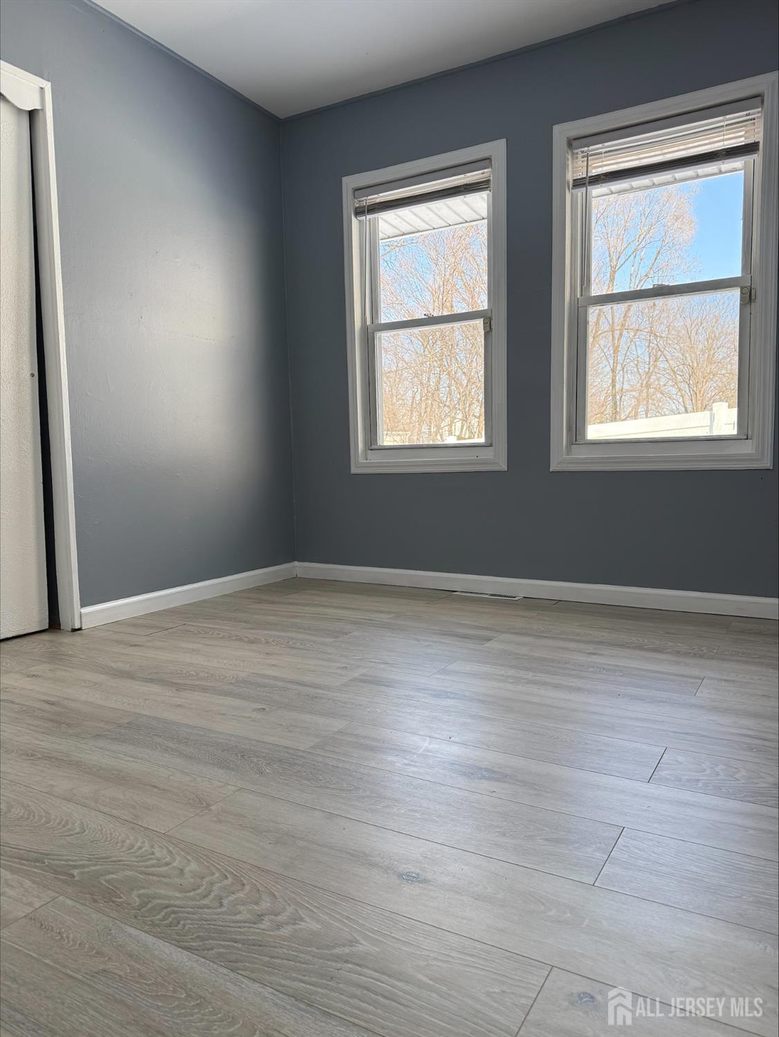 1211 Stelton Road Piscataway, NJ 08854 - Photo 10 of 16 an empty room with wooden floor and windows