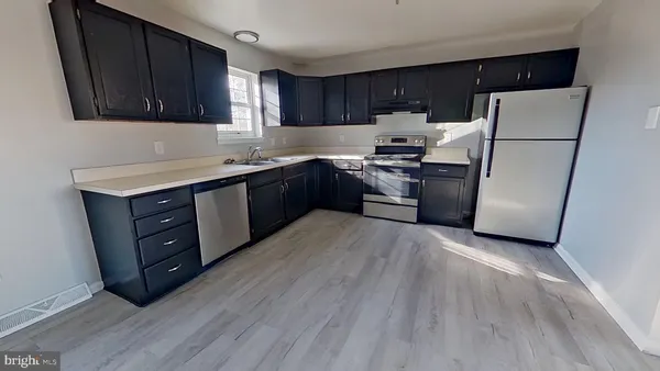 a kitchen with a refrigerator and a stove top oven
